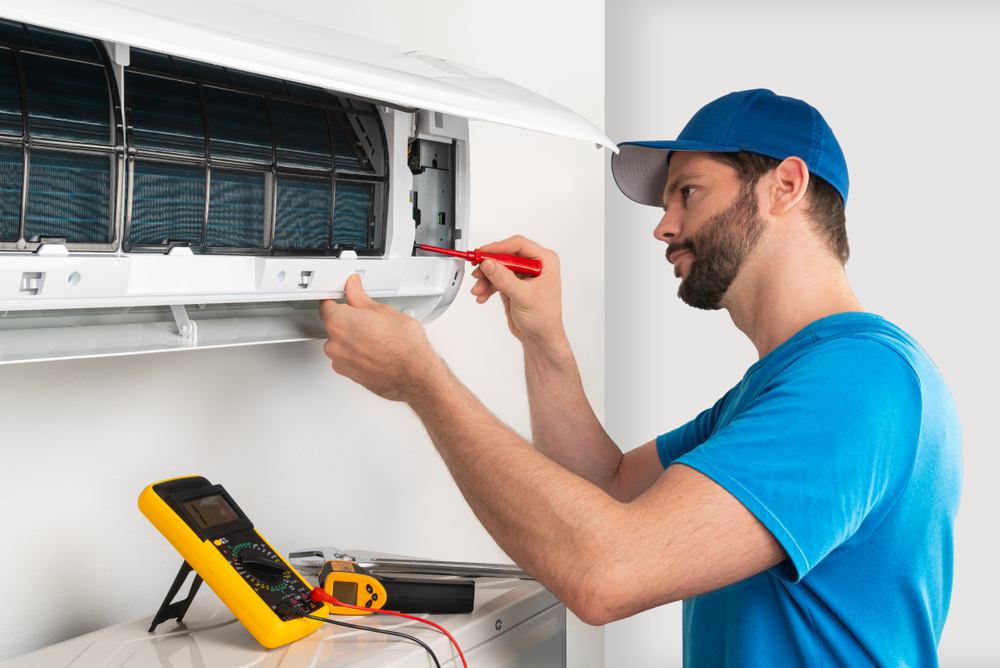 A technician works on an air conditioning unit, highlighting AC repair services in Fort Collins, CO.