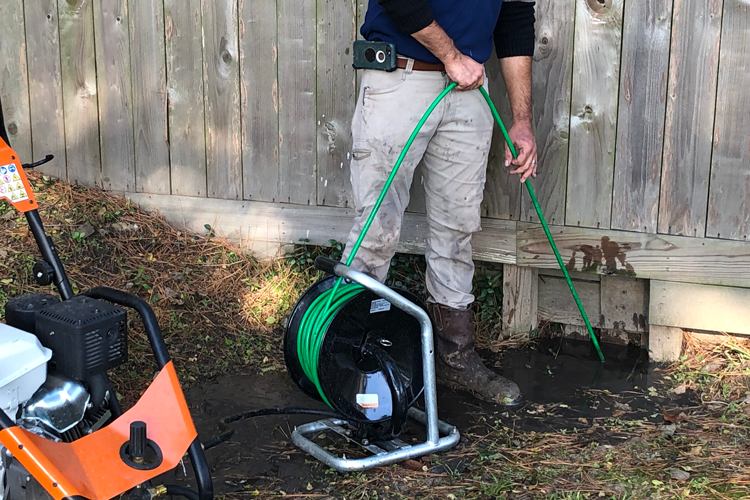 An Allen Service Technician at the Lawn Area Performing Drain Cleaning Services in Fort Collins, CO