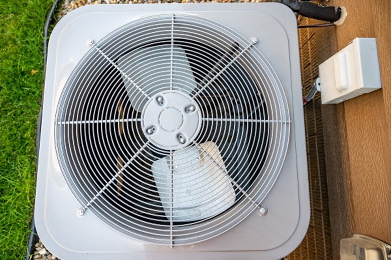 A white air conditioning unit on a wooden deck keep your AC running smoothly in Fort Collins, CO
