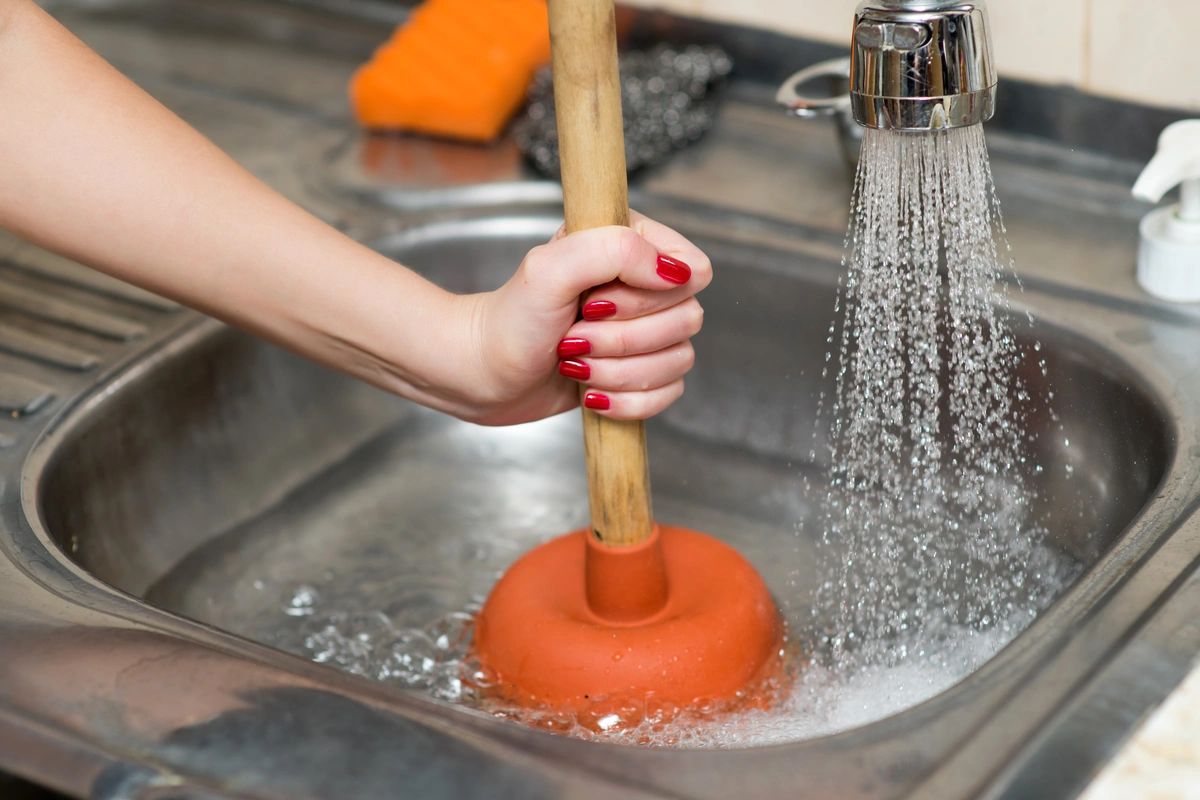 A person in Fort Collins, CO clean a sink, addressing issues that create a clogged drain
