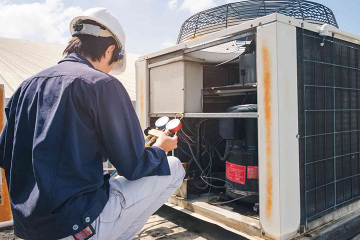 A woman sits on a couch, considering AC inspection and unit replacement in Fort Collins, CO